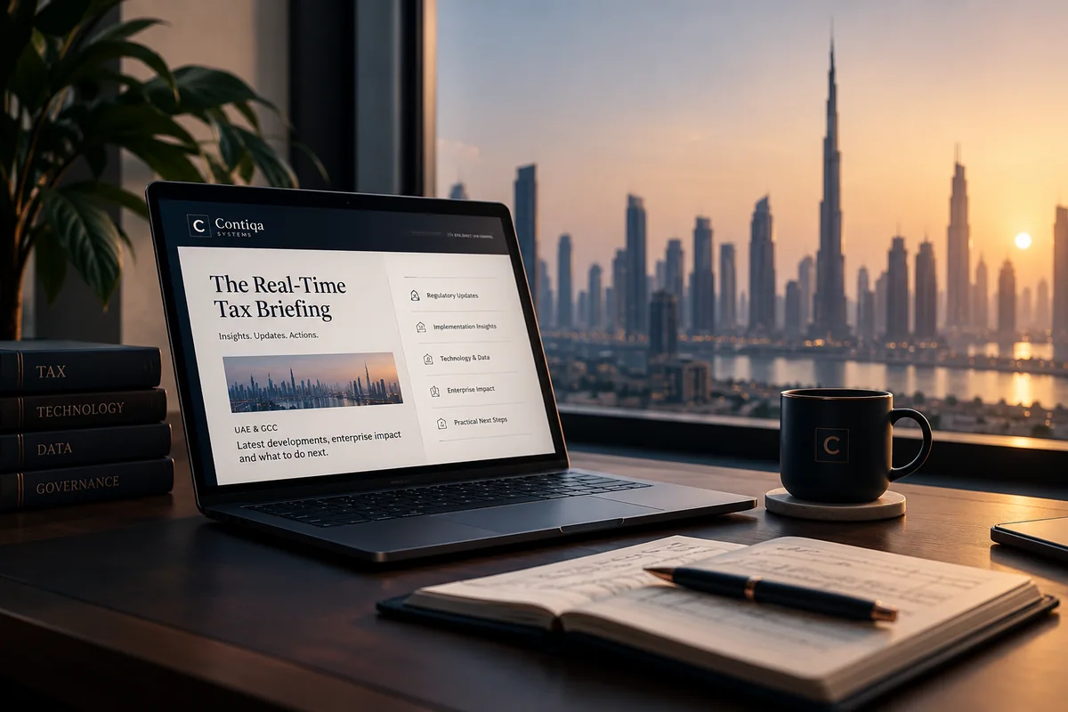 The Real-Time Tax Briefing open on a laptop at a Dubai desk, with volumes on tax, technology, data and governance alongside